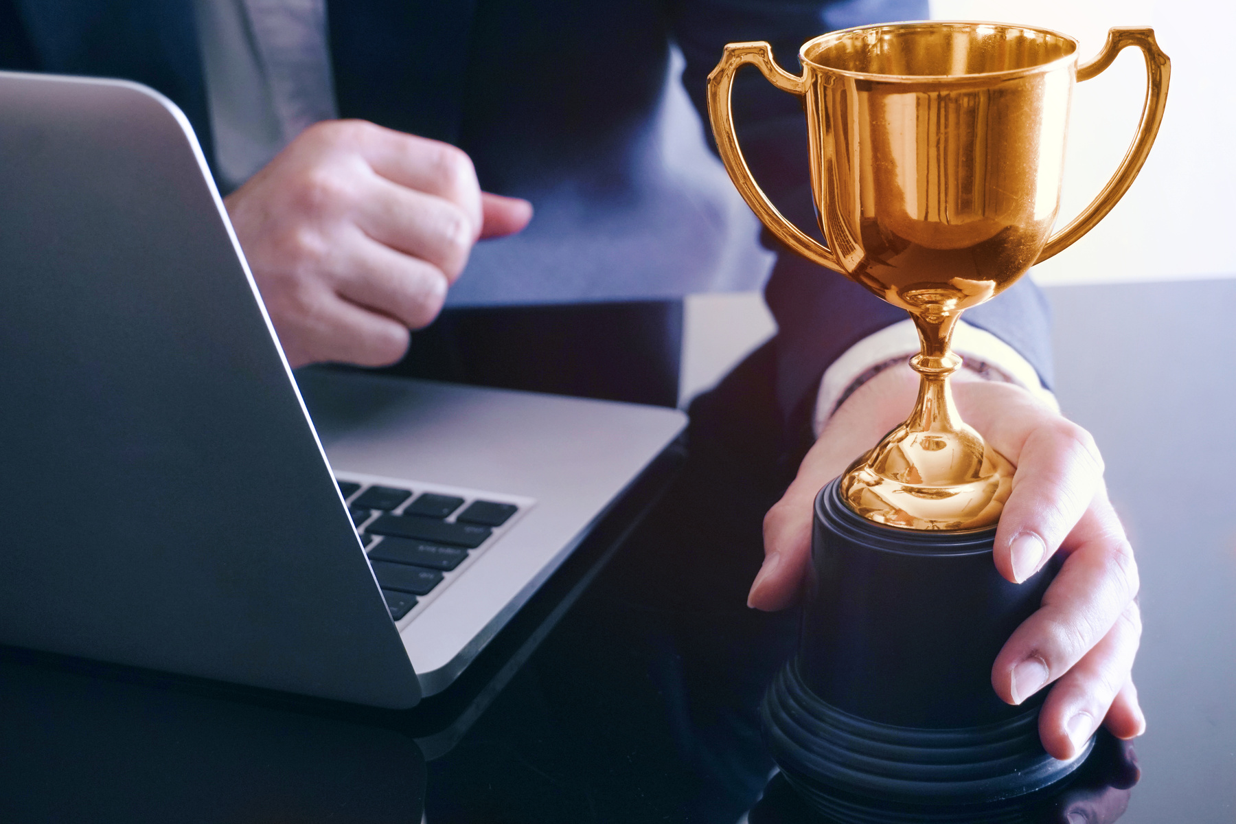 Businessman is holding trophy which lay on the table,achive business concept.